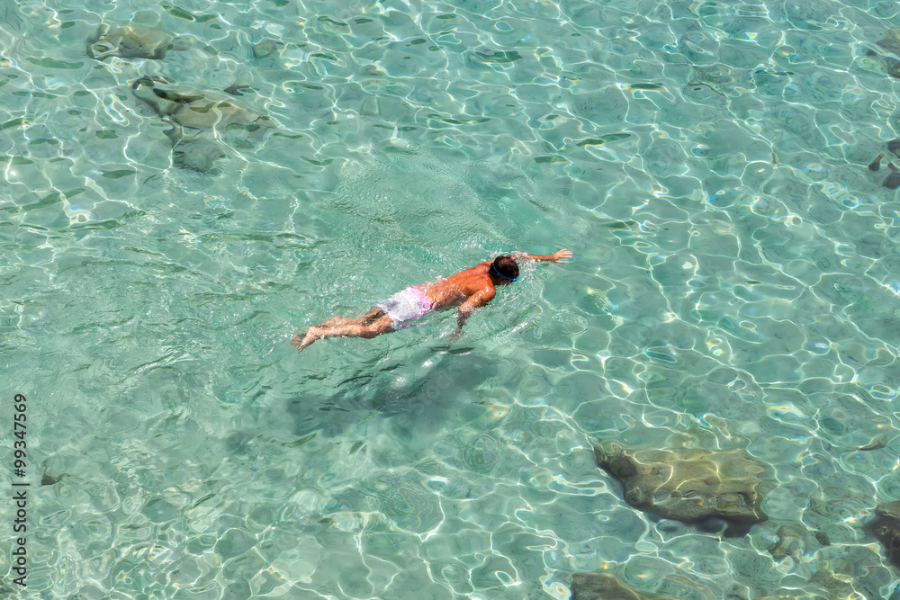 Top view of a boy swimming at Milos, in Greece