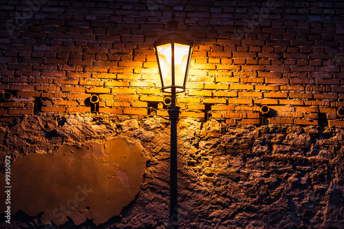 Obraz na plátne Vintage street lamp against a brick wall at night