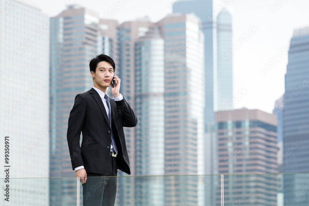 Asian Businessman make a call on cellphone at Hong Kong Asian Businessman make a call on cellphone at Hong Kong