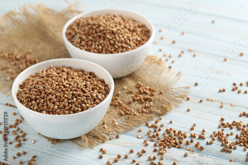 Buckwheat seeds in bowl on a blue wooden table
