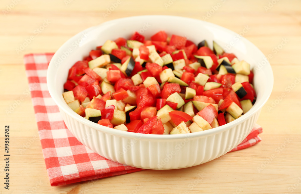 Ratatouille, stewed vegetable dish with tomatoes, zucchini, eggplant before cooking, on wooden background Ratatouille, stewed vegetable dish with tomatoes, zucchini, eggplant before cooking, on wooden background