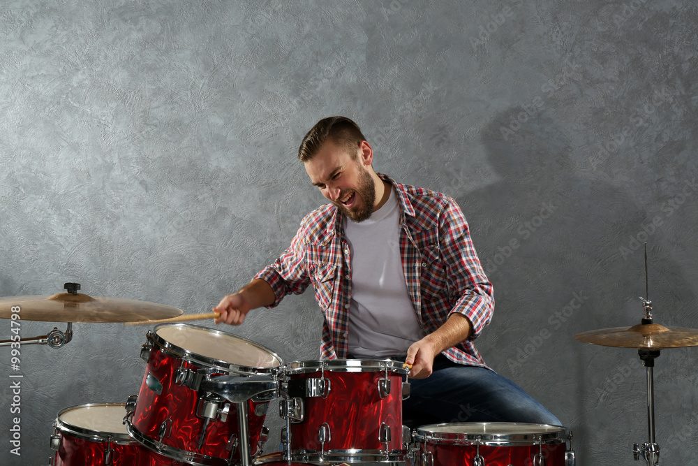 Musician playing the drums on brick wall background Musician playing the drums on brick wall background