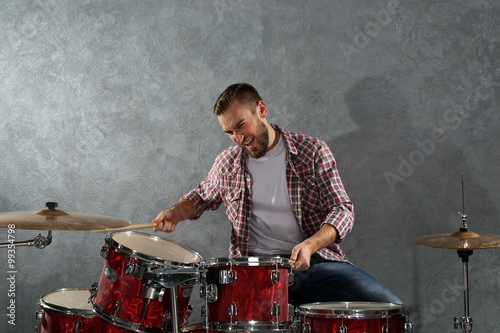 Musician playing the drums on brick wall background