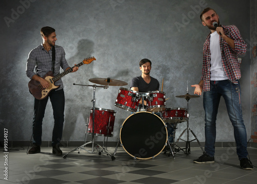 Musicians playing musical instruments and singing songs in a studio