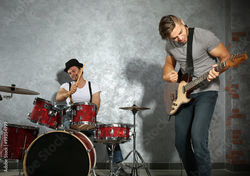 Musicians playing musical instruments and singing songs in a studio