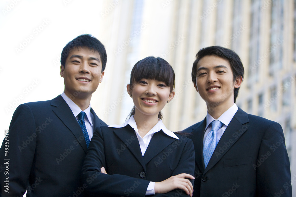 Three business professionals in front of skyscraper Three business professionals in front of skyscraper