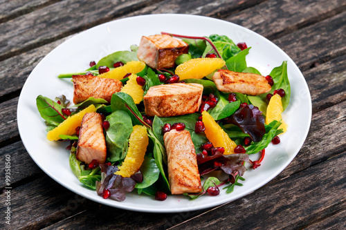 Fresh Salmon Salad with vegetables, pomegranate and orange.