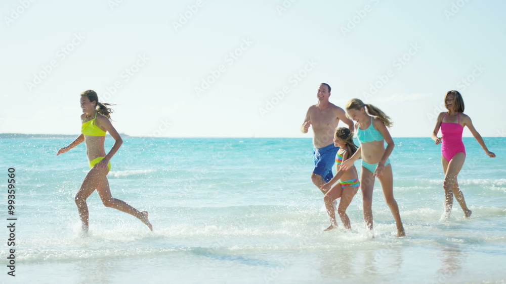 Young Caucasian family in swimwear having fun on beach Young Caucasian family in swimwear having fun on beach