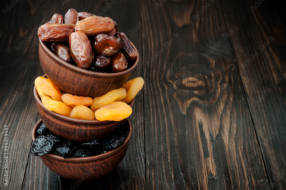 Mix of dried fruits and nuts on dark wood background with copy space. Symbols of judaic holiday Tu Bishvat Mix of dried fruits and nuts on dark wood background with copy space. Symbols of judaic holiday Tu Bishvat