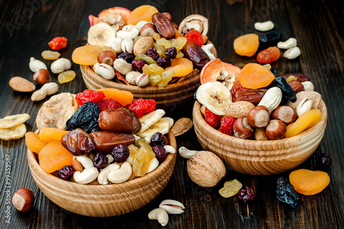Tableau sur toile Mix of dried fruits and nuts on dark wood background
