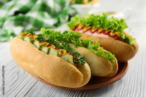 Delicious hot-dogs on white wooden table, close up