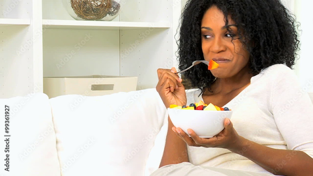 young healthy ethnic female girl home couch indoors eating fresh organic fruit