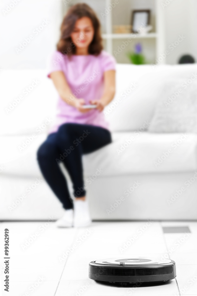 Cleaning concept - automatic robotic hoover clean the room while woman relaxing, close up Cleaning concept - automatic robotic hoover clean the room while woman relaxing, close up