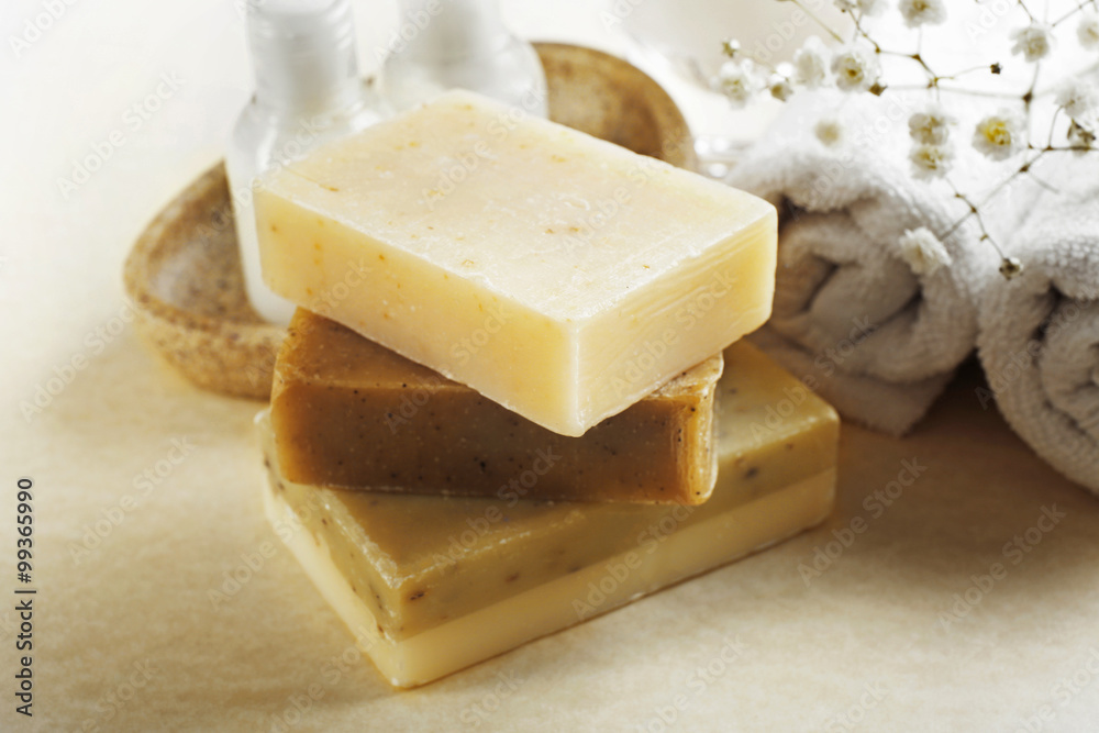 Soap set and towels on a beige background, close up