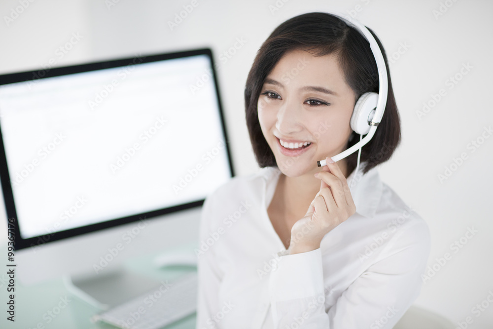 Cheerful businesswoman with headset in office