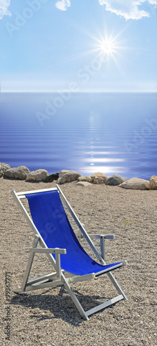 leerer Liegestuhl am Strand  Blaues Wasser und strahlender Sonne