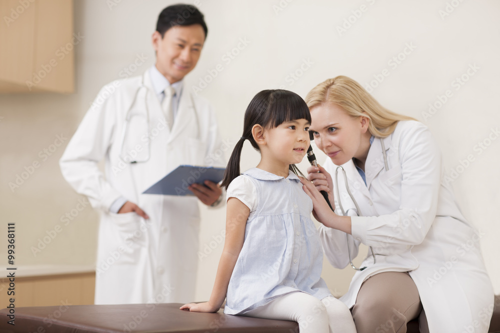 Doctor examining girl's ears Doctor examining girl's ears