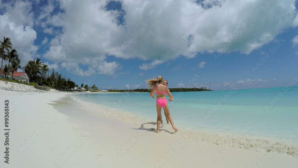 Young female Caucasian children in swimwear on tropical beach Young female Caucasian children in swimwear on tropical beach