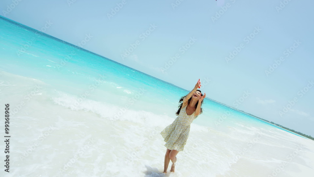 Smiling Asian Chinese girl playing with red kite on beach Smiling Asian Chinese girl playing with red kite on beach
