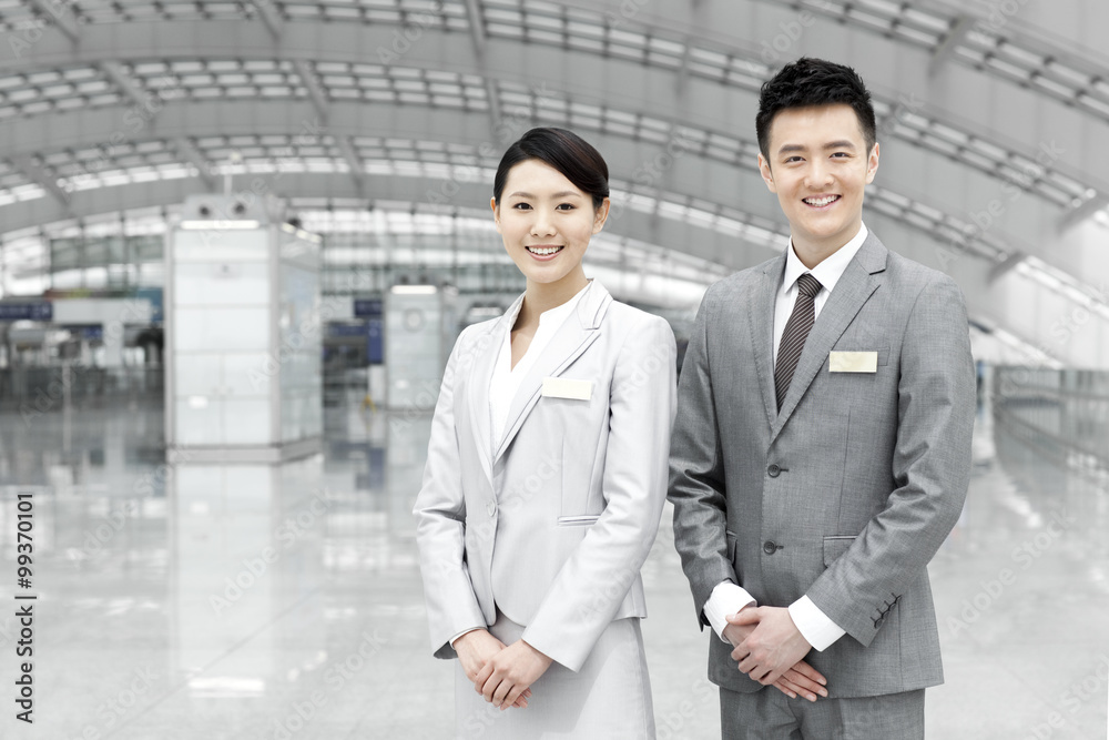 Chinese airport staff members in airport lobby Chinese airport staff members in airport lobby