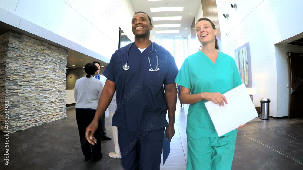 Multi ethnic professional staff consulting in medical centre entrance