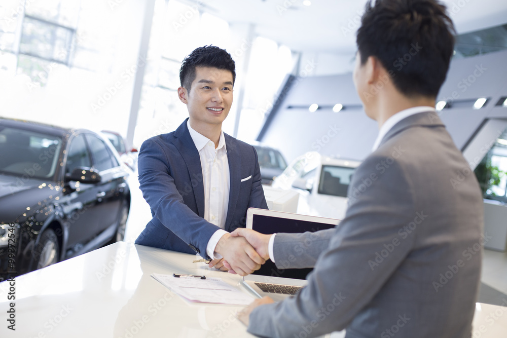 Young man buying car in showroom Young man buying car in showroom