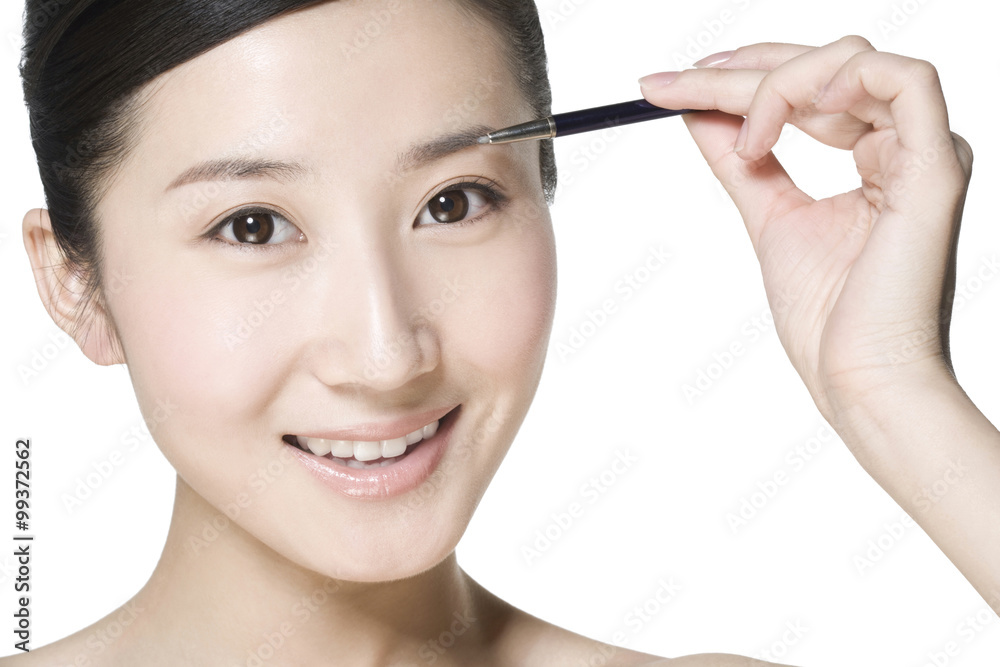 Beauty shot of a young woman penciling eyebrow Beauty shot of a young woman penciling eyebrow