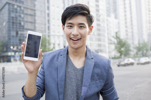 Confident young man showing smart phone