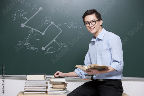 Confident Male teacher giving lessons in classroom