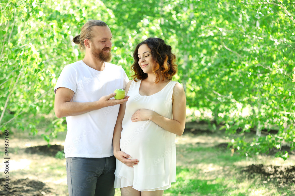 Together in waiting of baby's birth - happy man and woman in the park Together in waiting of baby's birth - happy man and woman in the park