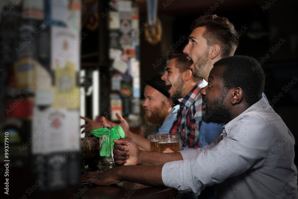 Young men drinking beer in pub Young men drinking beer in pub