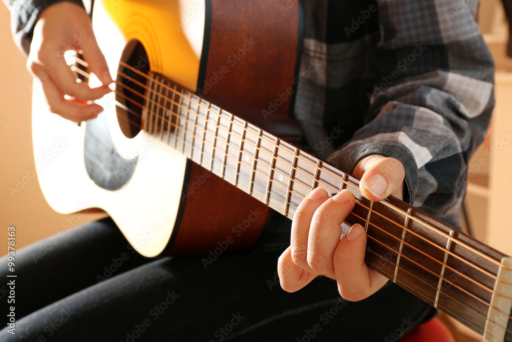 Fototapeta premium Guitarist plays guitar in the studio, close up