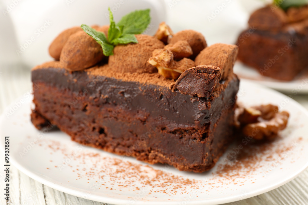 Piece of chocolate cake with walnut and mint on the table, close-up Piece of chocolate cake with walnut and mint on the table, close-up