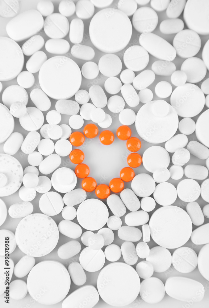 Heart of red pills on white pills background Heart of red pills on white pills background