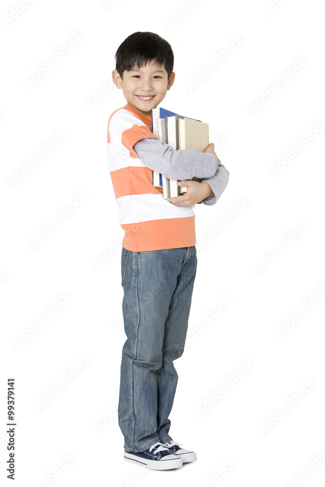 Happy young boy carrying a stack of books Happy young boy carrying a stack of books