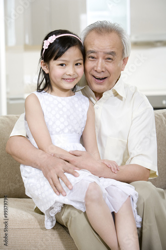 Portrait of grandfather and granddaughter at home