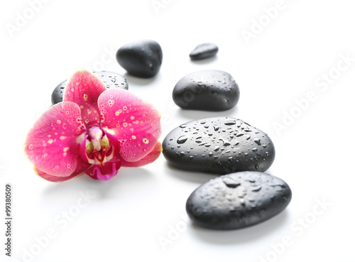 Black spa stones and orchids isolated on white