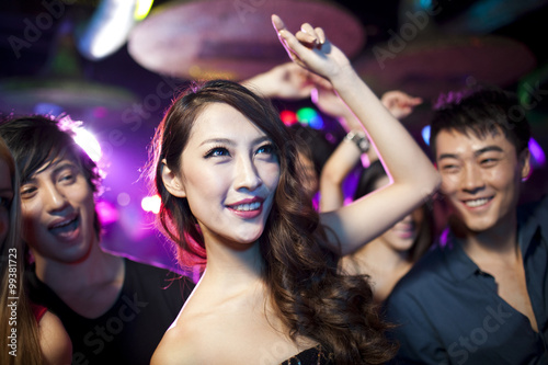 Stylish young people dancing in nightclub photo