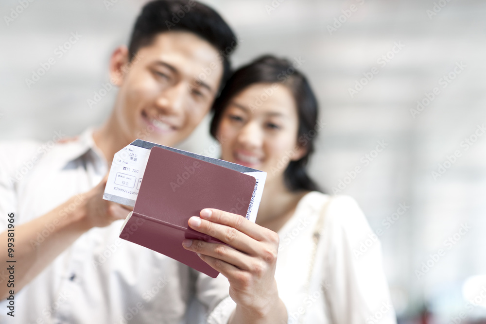 Young couple at the airport with flight tickets and passports Young couple at the airport with flight tickets and passports