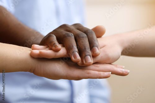 Fototapeta Naklejka Na Ścianę i Meble -  White caucasian and black afro american hands holding together, friendship concept