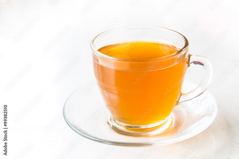 Hot aromatic honey tea in transparent cup and saucer Hot aromatic honey tea in transparent cup and saucer