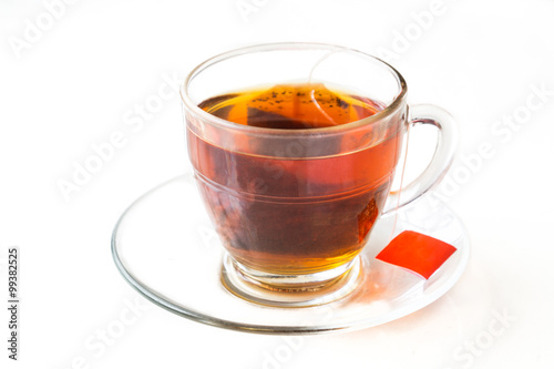 Hot tea with tea bag in transparent cup and saucer