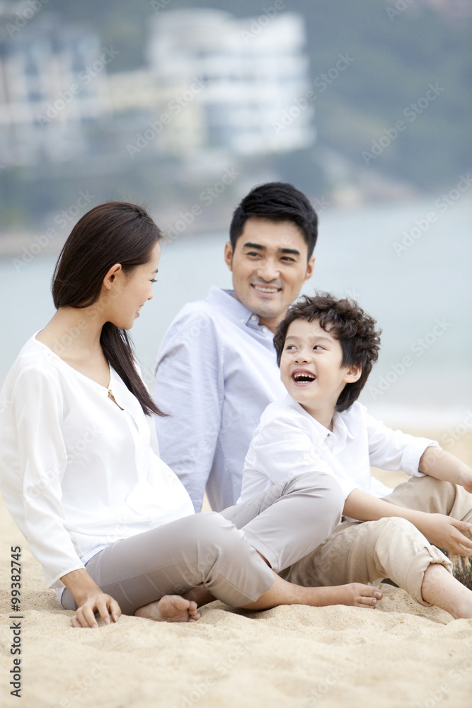 Happy young family relaxing themselves on the beach of Repulse Bay, Hong Kong Happy young family relaxing themselves on the beach of Repulse Bay, Hong Kong