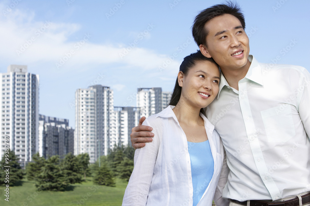Man And Woman Hugging In Front Of Cityscape Man And Woman Hugging In Front Of Cityscape