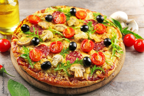 Delicious tasty pizza with ingredients on wooden table