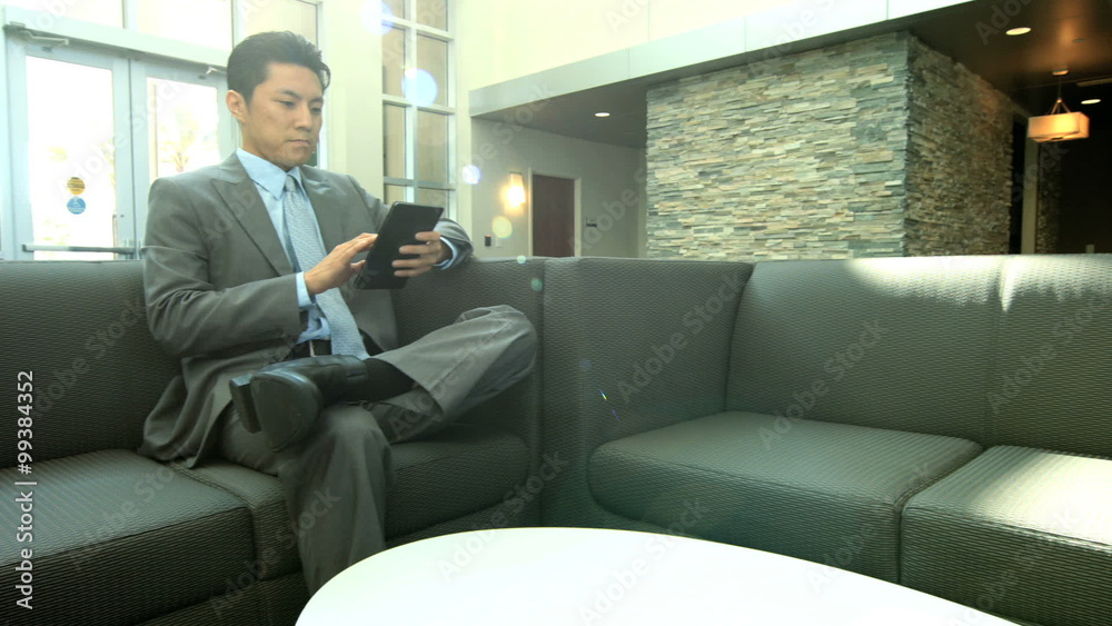 Asian Chinese businessman using touch screen mini tablet in office