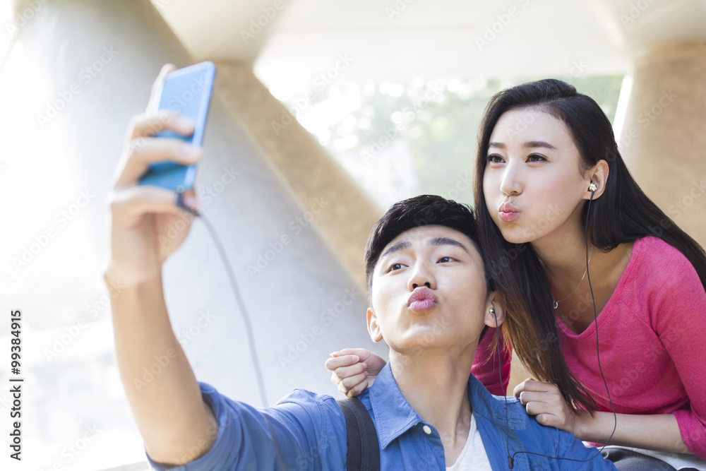 Young couple taking self portrait with a smart phone Young couple taking self portrait with a smart phone