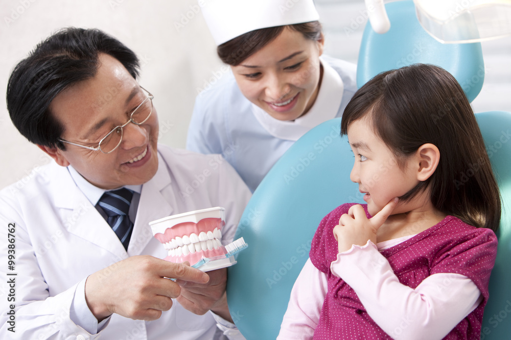 Dentist teaching the right way of brushing teeth Dentist teaching the right way of brushing teeth