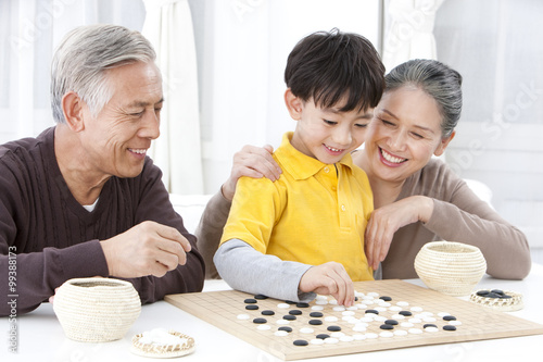 Grandparents and grandson playing Chinese Weiqi photo