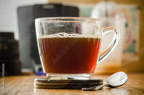 The cup of hot coffee on wooden background in the morning